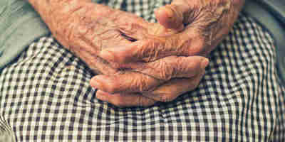 Elderly lady hands interlinking on her lap. Understanding and navigating client capacity in legal proceedings—The Solicitors Journal 