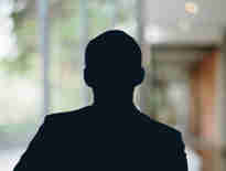 Russell-Cooke Solicitors staff photograph. Silhouette of a female team member against the backdrop of an office window and corridor with a soft focus effect.