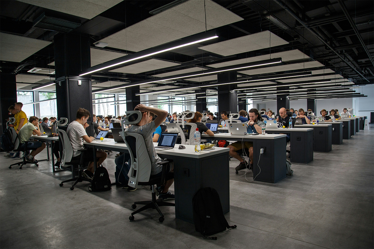 A large office with rows of office workers at computers. 