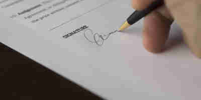 A person signing legal documentation. LPAs—stepping into the digital age with changes afoot 