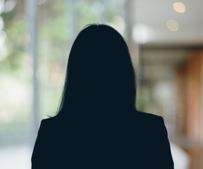 Russell-Cooke Solicitors staff photograph. Silhouette of a female team member against the backdrop of an office window and corridor with a soft focus effect.