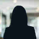 Russell-Cooke Solicitors staff photograph. Silhouette of a female team member against the backdrop of an office with a soft focus effect.