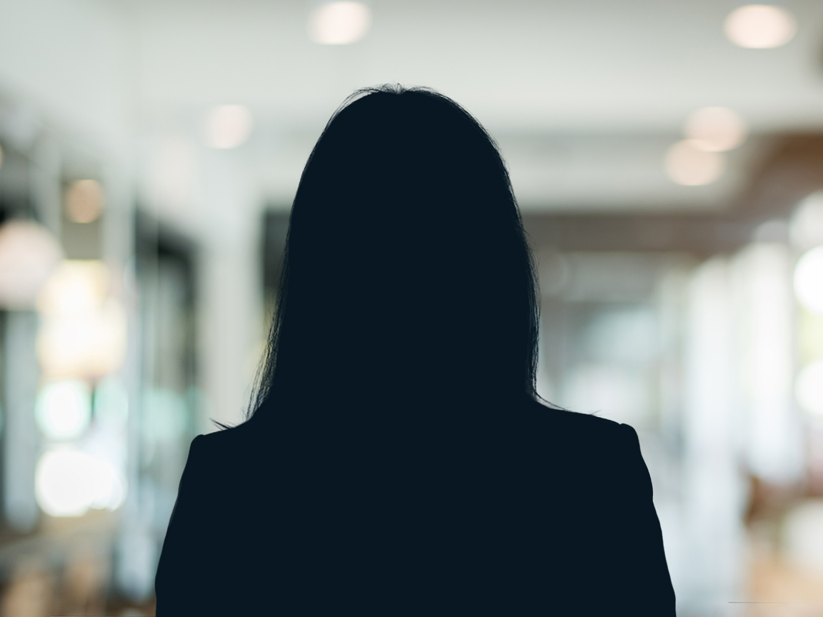 Russell-Cooke Solicitors staff photograph. Silhouette of a female team member against the backdrop of an office with a soft focus effect.