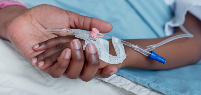 Mother holding the hands of a small child with an IV drip. Infectious diseases and sepsis claims for children.