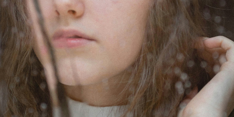 Solicitor helping family win compensation for child's surgical injury. Image of young girl looking out of a rain covered window.
