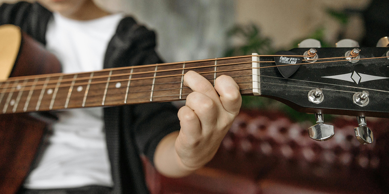a young boy playing a guitar. Russell-Cooke advises on lease for School of Rock’s first UK location