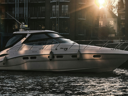 The image shows a small white yacht on water