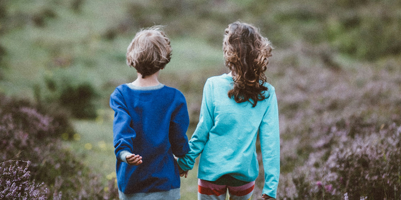Three young male children running through a field. Championing children’s voices: Children’s Mental Health Week 2024