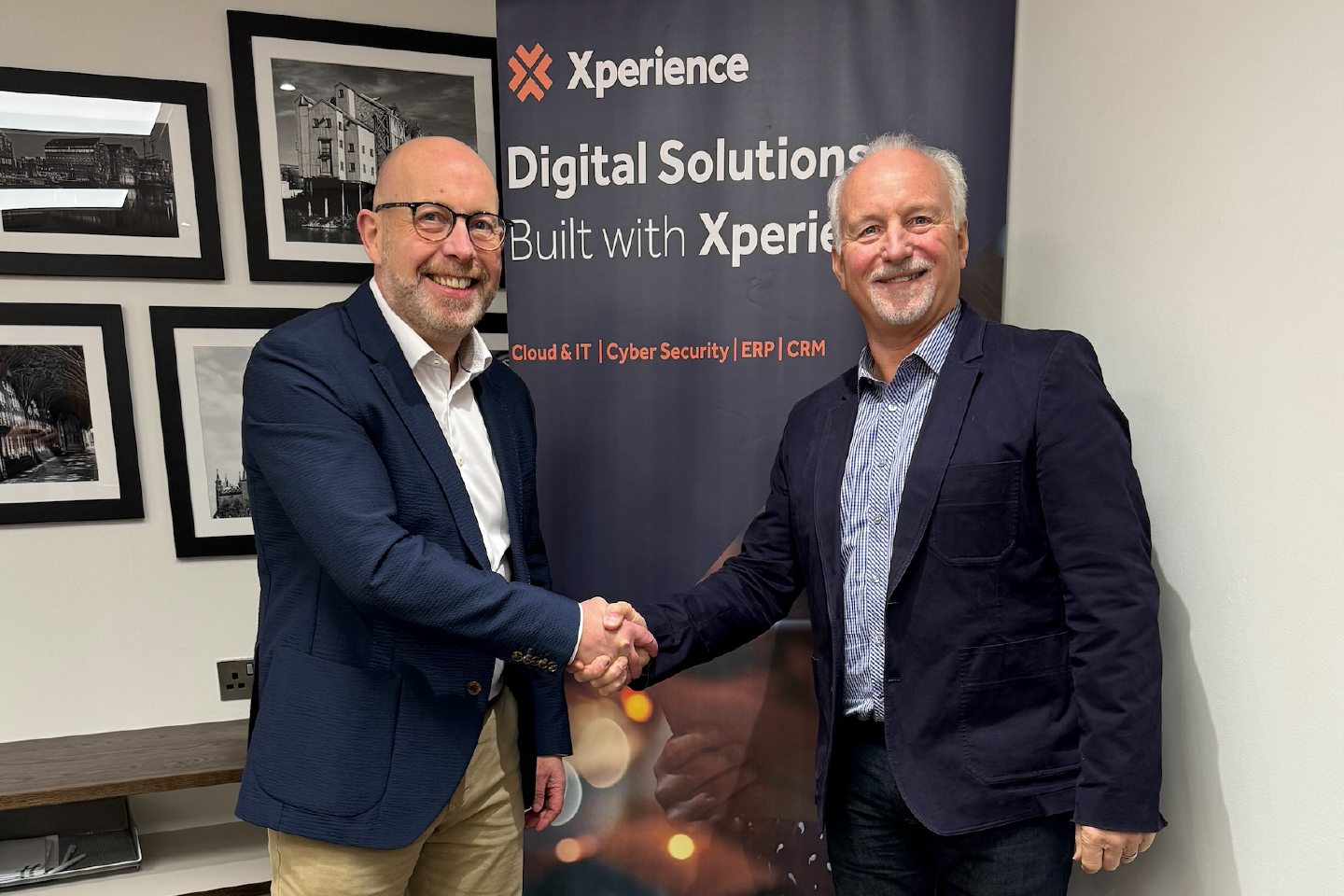 Iain O'Kane and Chris Harthman shake hands on a deal on the sale of GCC Group to Xperience. 