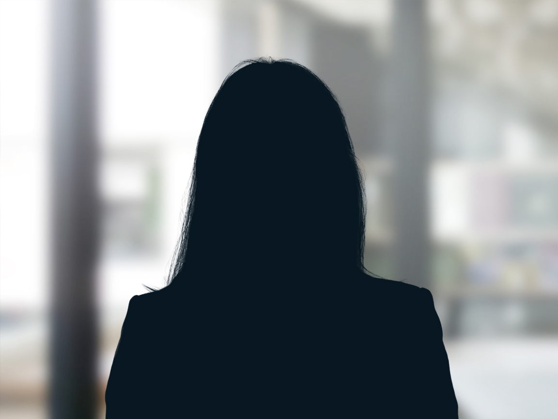 Russell-Cooke Solicitors staff photograph. Silhouette of a female team member against the backdrop of an office window with a soft focus effect.