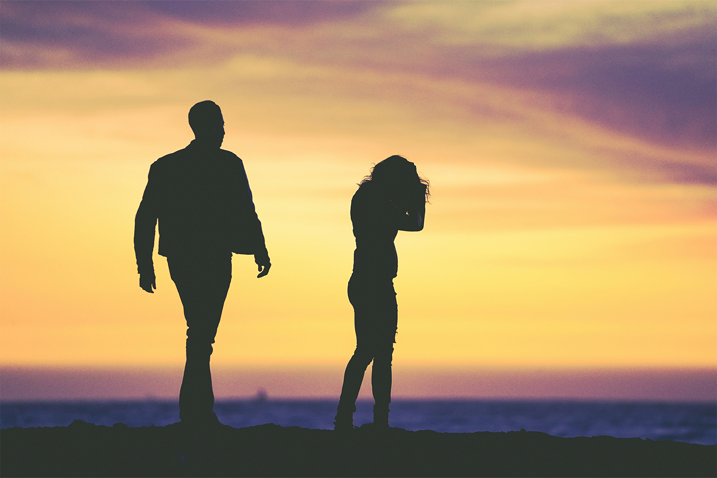 A male and female silhouette appearing to be arguing in front of a sunset. ‘How has my ex-husband ended up living off me for the rest of his life?’—The Telegraph