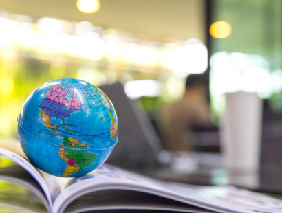 Miniature globe placed on an open textbook | Russell-Cooke charity law and nonprofits  team helping charities and nonprofits navigate the legal and regulatory challenges of working internationally