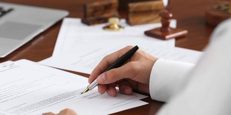 A person signing a legal document. Russell-Cooke obtains rare Welfare Deputyship on behalf of family of SEN young adult