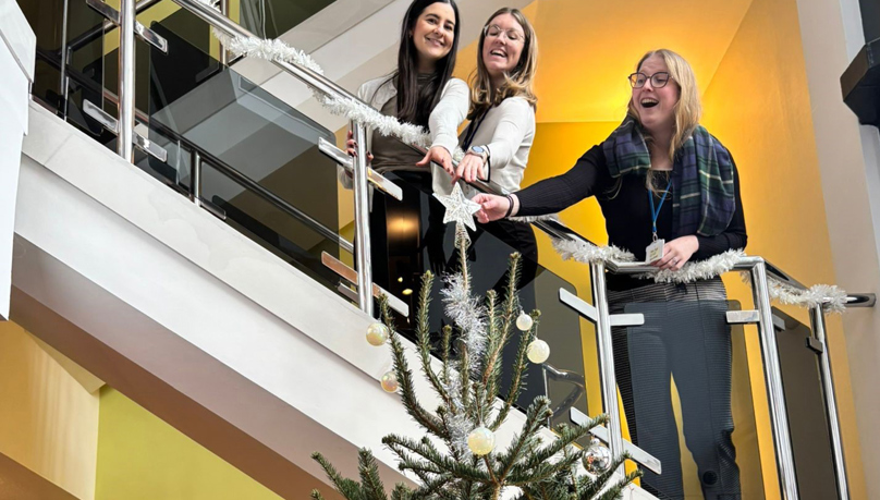 Trainees decorating the Christmas tree in the Putney office.