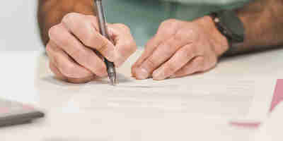 man signing paperwork. Future general election and the impact on IHT -  inheritance tax. 