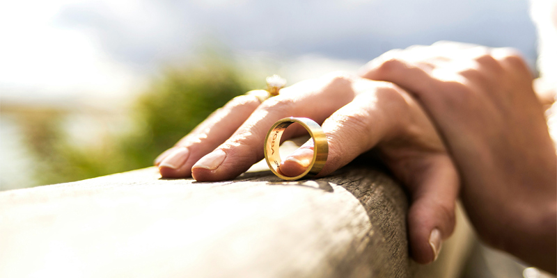 A person holding a wedding band on a bench / fence. Key lessons for family lawyers as relationship landscapes change and rise of ‘no-fault divorces’—Today’s Family Lawyer