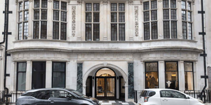 The Impress Building, Mayfair, London. Two cards (grey and white) in front of a heritage building, stoned bricks and large double-fronted bay windows. Russell-Cooke advises Tokoro Capital on refinancing of historic £130m Empress and Ada buildings in Mayfair London