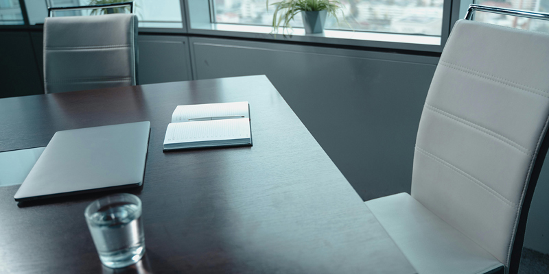 Empty leather seats by a desk in an office.