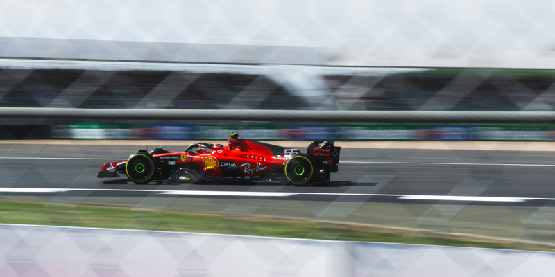 The picture shows a red formula 1 racecar on the circuit at Silverstone