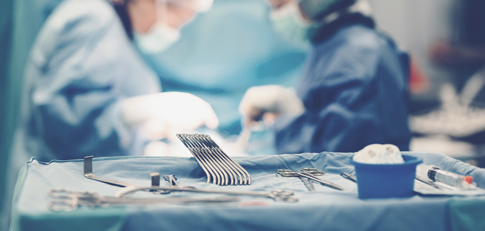 Surgeons in operating room, with medical equipment in the foreground. Surgical claims for children