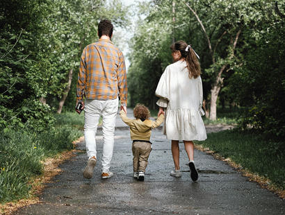 The image shows a family walking down a road. 