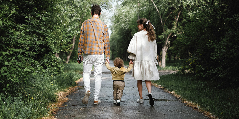 The image shows a family walking down a road. 