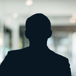 Russell-Cooke Solicitors staff photograph. Silhouette of a male team member against the backdrop of an office with a soft focus effect.