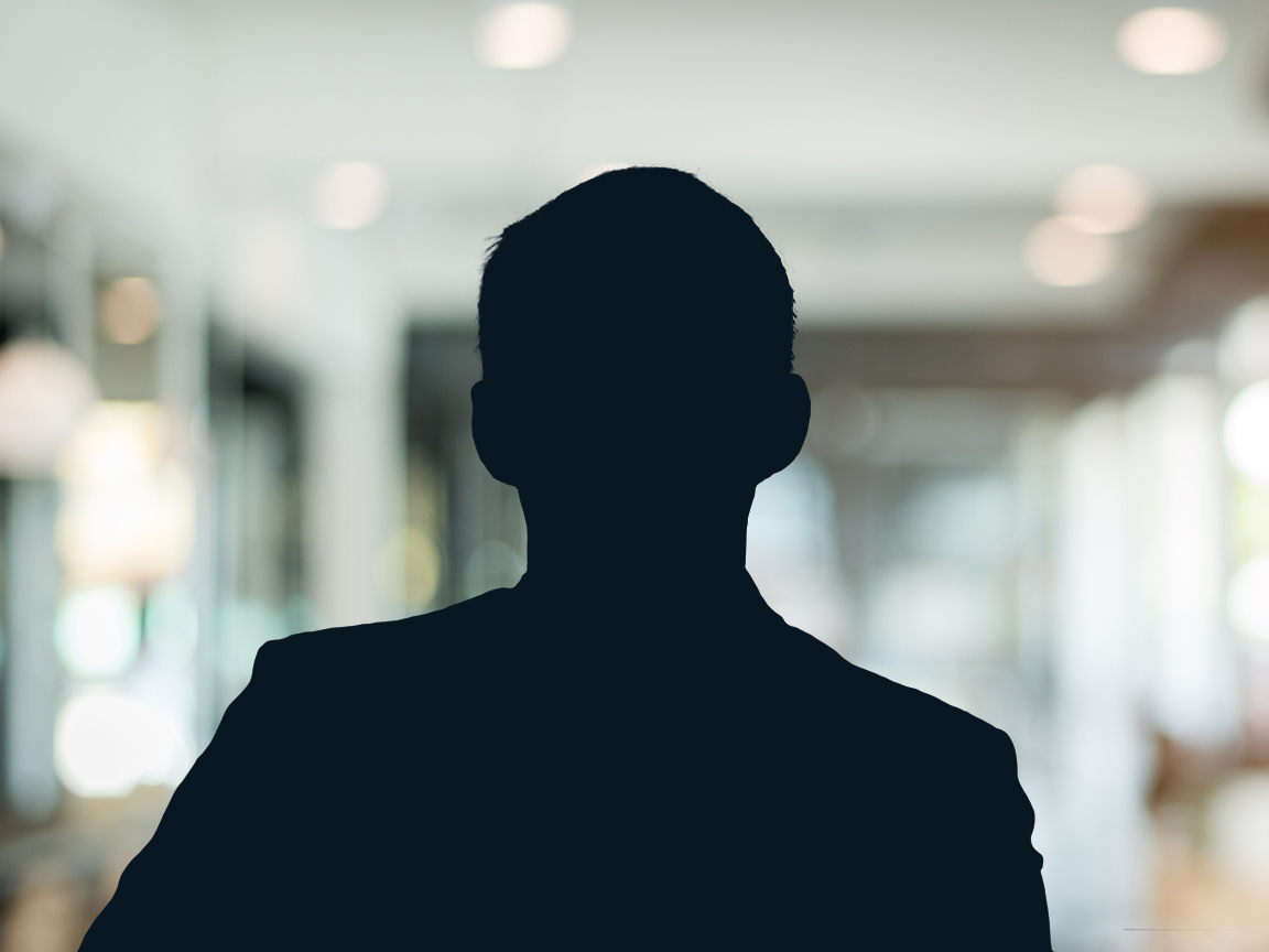 Russell-Cooke Solicitors staff photograph. Silhouette of a male team member against the backdrop of an office with a soft focus effect.