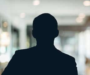 Russell-Cooke Solicitors staff photograph. Silhouette of a male team member against the backdrop of an office with a soft focus effect.