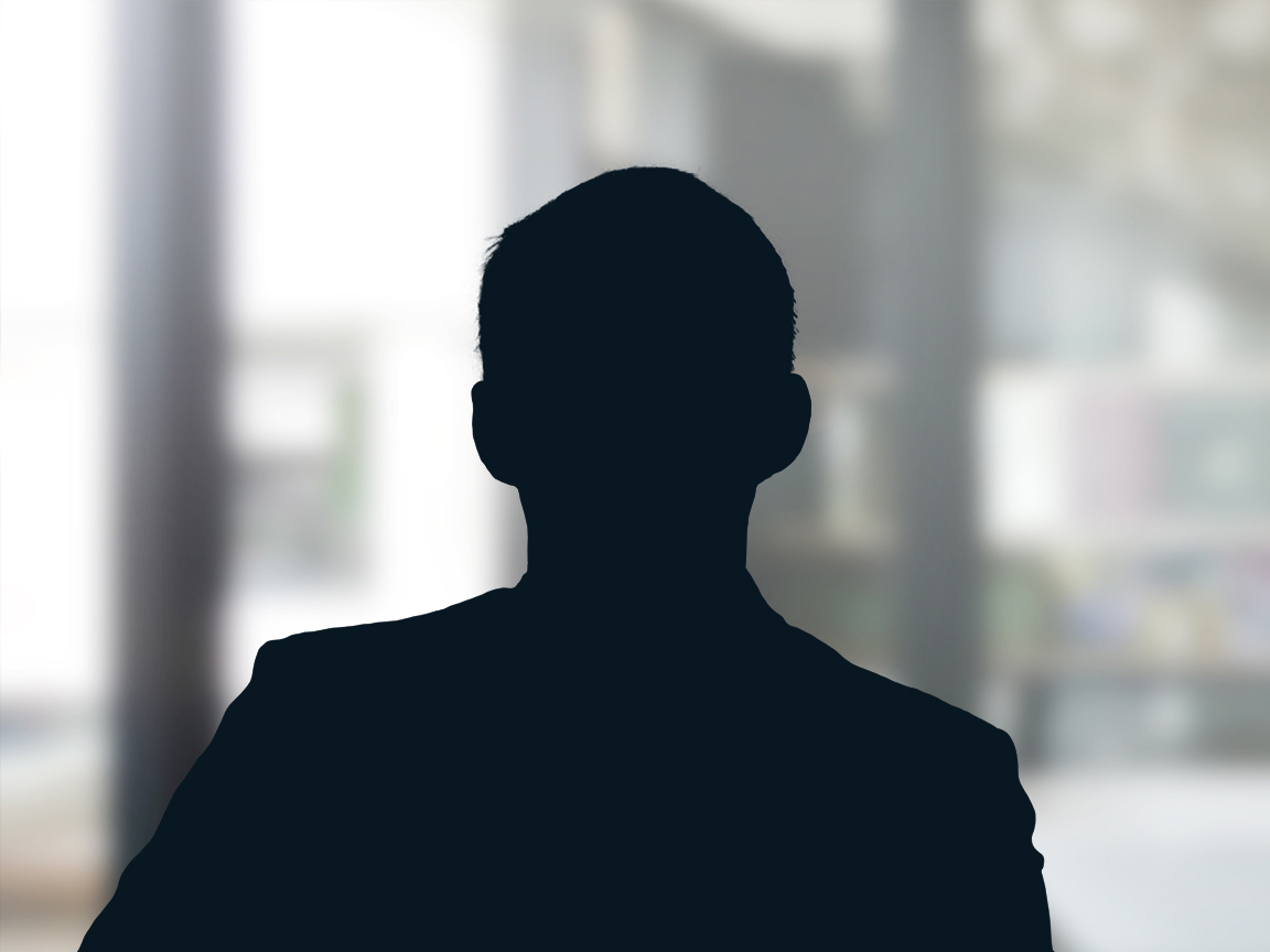 Russell-Cooke Solicitors staff photograph. Silhouette of a male team member against the backdrop of an office window with a soft focus effect.