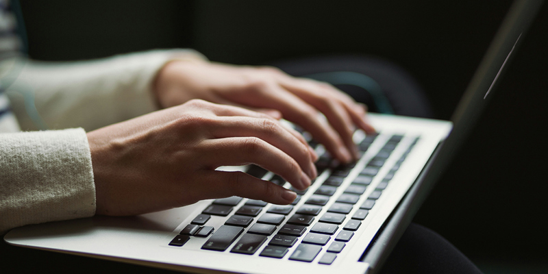 Person typing on laptop keyboard