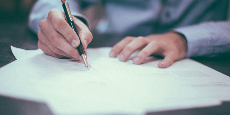 A man signing formal documents. Part 36 Offers: navigating the fine line between a ‘tactical’ offer and abuse of the regime—Solicitors Journal