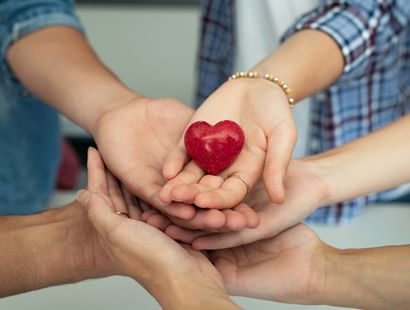 group of hands holding a heart
