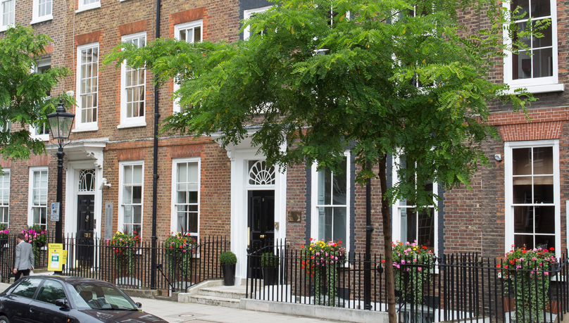 The picture shows Georgian townhouse buildings in London with high sash windows.