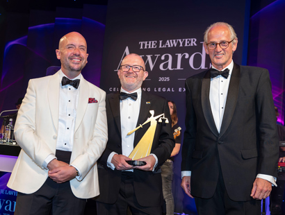 Three men smiling in black tie - the left man is in white blazer and the two men on the right are in black blazers. The man in the middle is holding the trophy. Russell-Cooke scoops Law Firm of the Year: The Independents at The Lawyer Awards