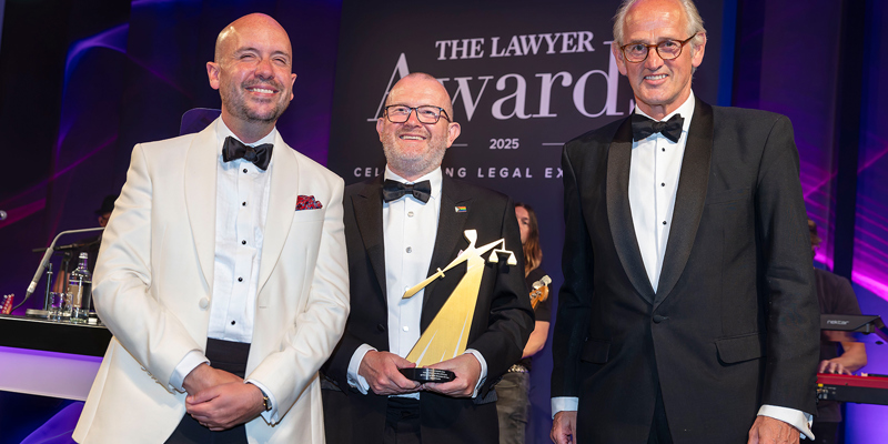 Three men smiling in black tie - the left man is in white blazer and the two men on the right are in black blazers. The man in the middle is holding the trophy. Russell-Cooke scoops Law Firm of the Year: The Independents at The Lawyer Awards