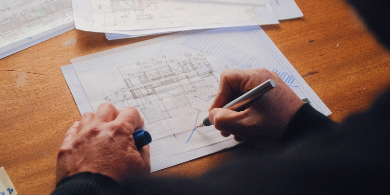 A man's hands drawings architectural floorplan drawings. Who owns the copyright after you pay an architect for drawings or plans? —The Times