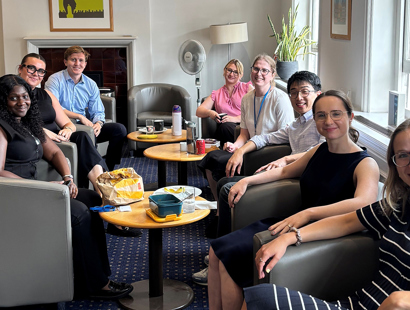 The picture shows a group of people sitting in armed chairs. 