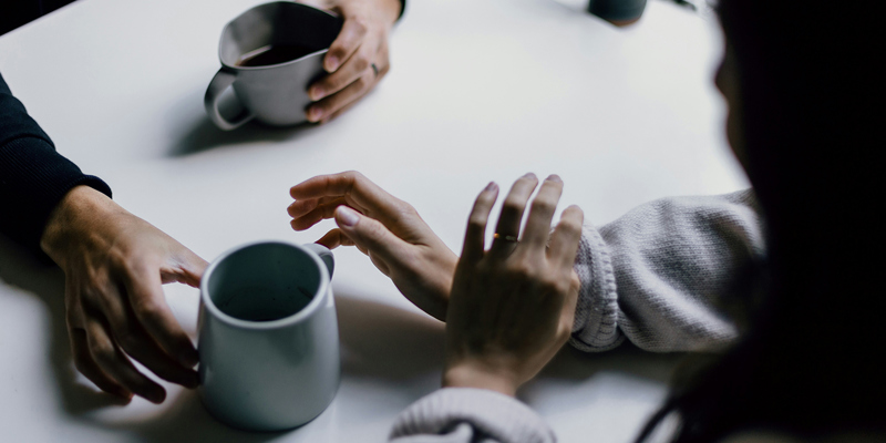 Two people having a conversation over coffee