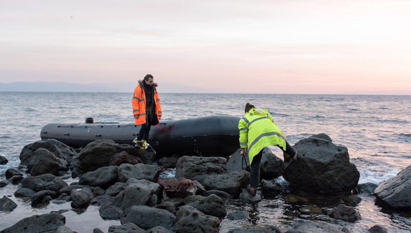 boat on rock in Greece and vulnteers in high vis clothing. Nina Stevens former search and rescue in Greece Russell-Cooke solicitors news 2023